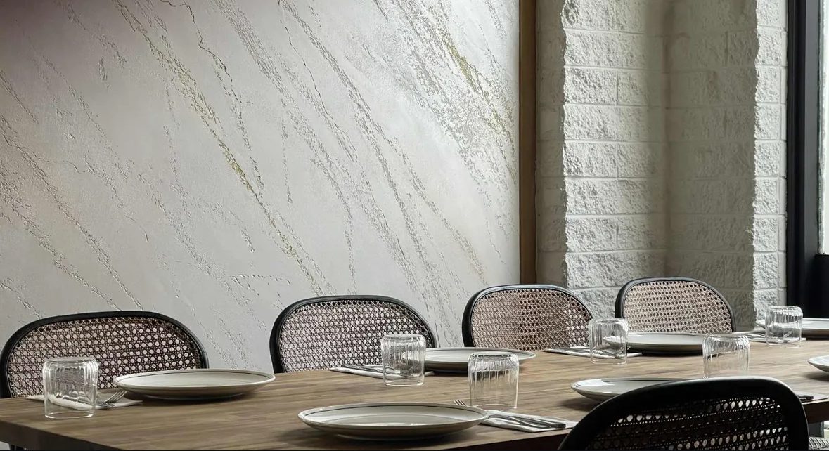 The dining room: cane chairs, timber tables and whitewashed stone